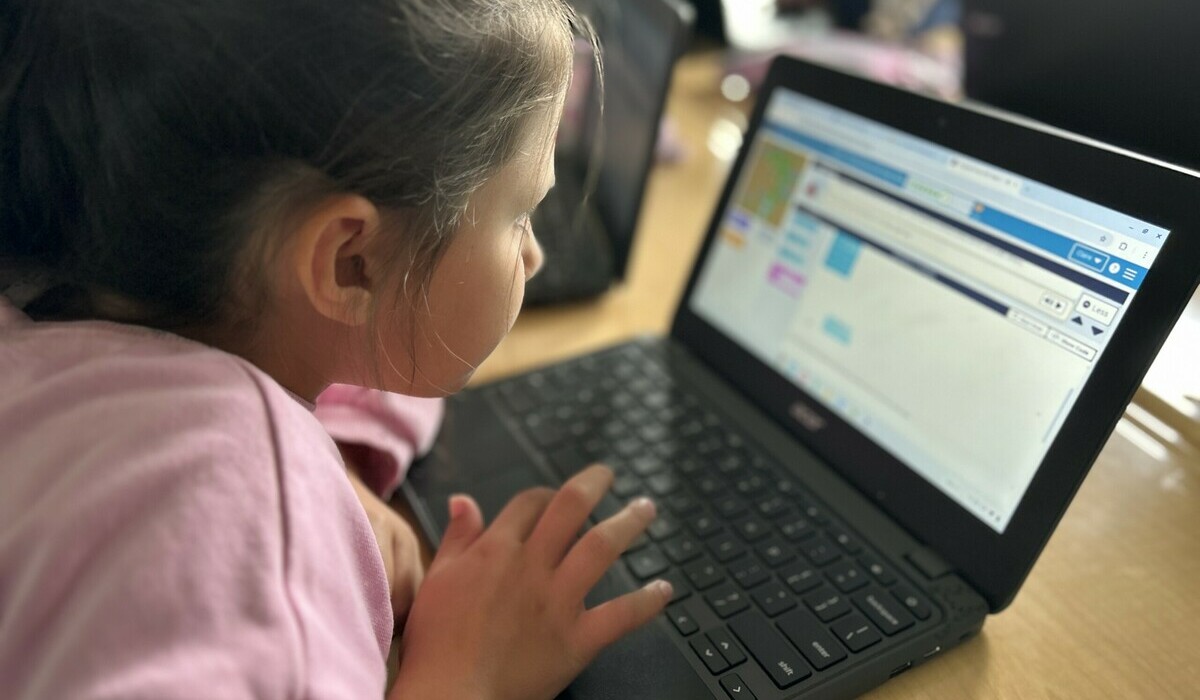 student at her desk with open laptop